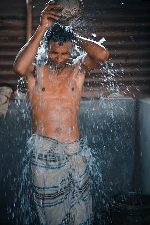 Young Afro-American Man Washing Face in Bathroom.