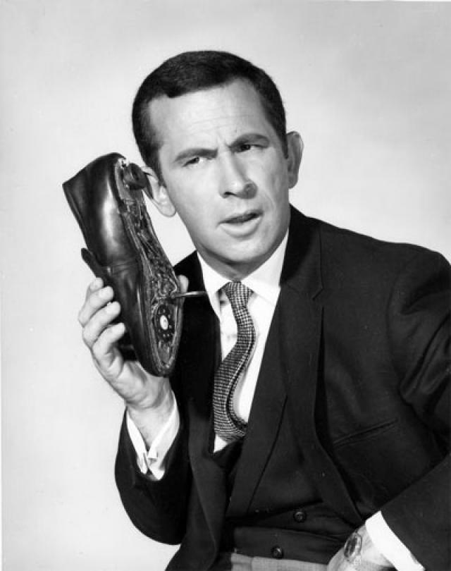 Don Adams, as Maxwell Smart, holding the famous shoe phone
