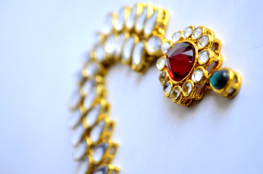 A gold pendant necklace featuring precious stones