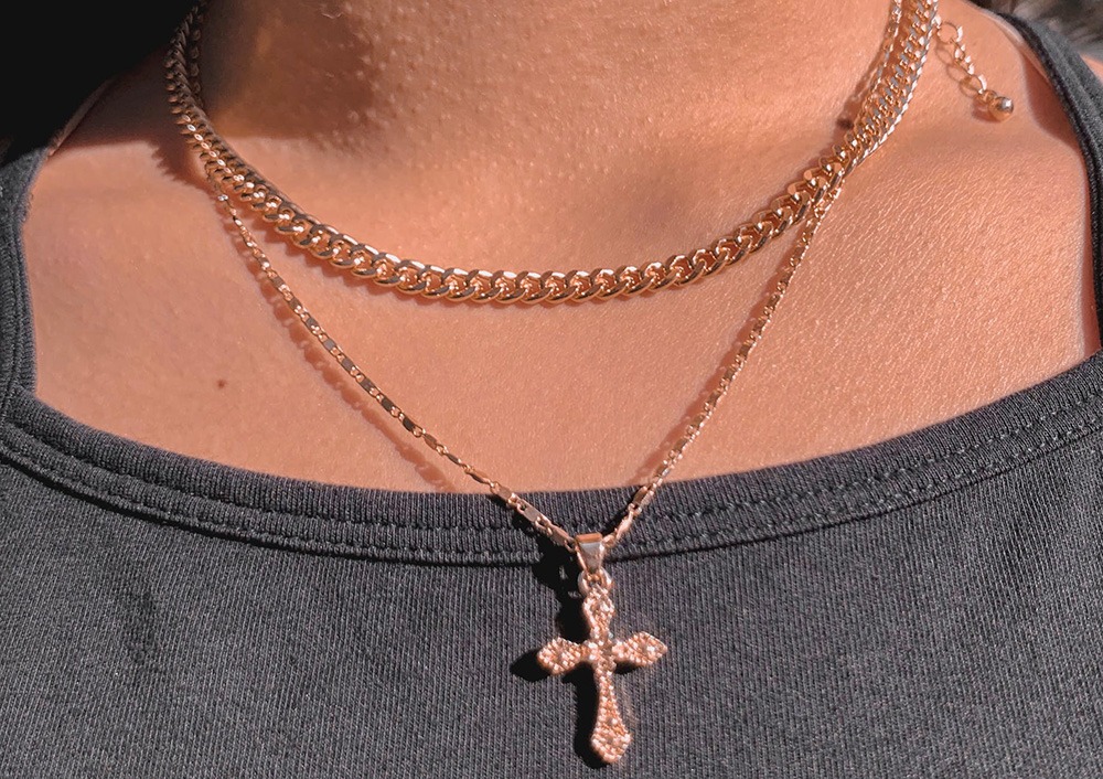 A rose gold chain necklace with cross