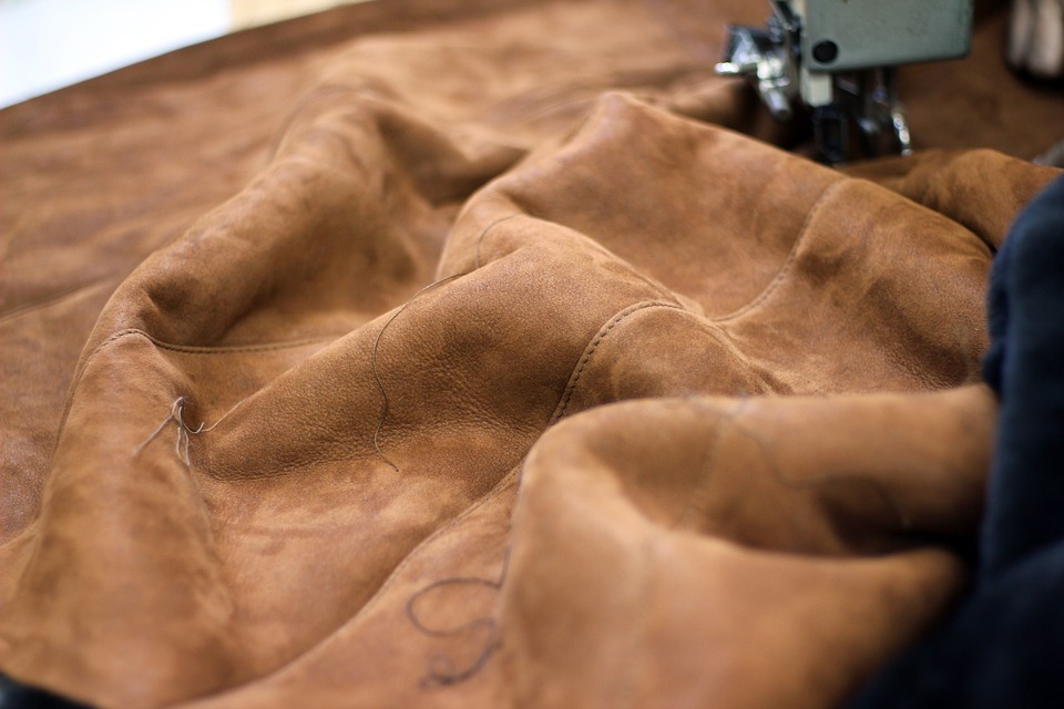 a piece of suede leather being sewn on a machine