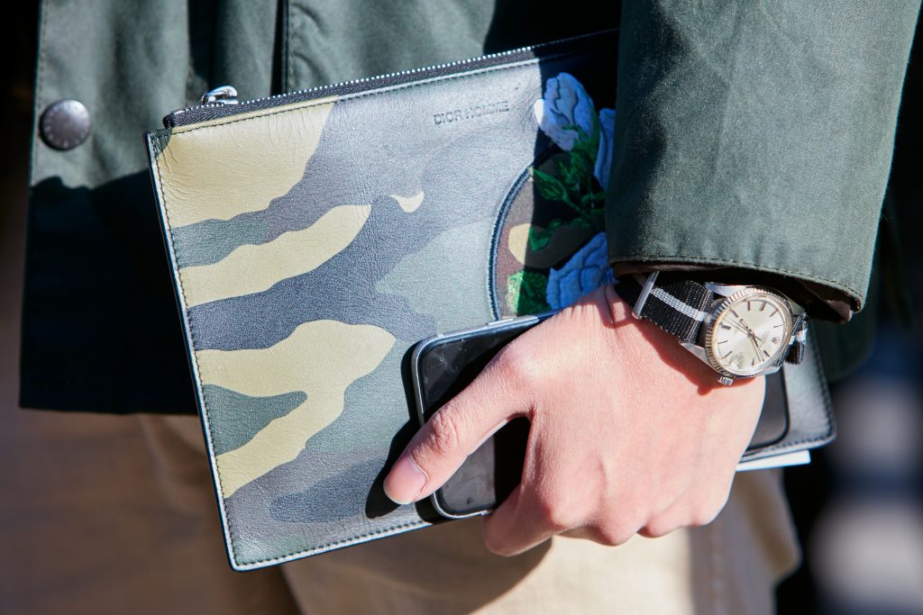 Man with green camouflage Dior bag and Rolex with Nato strap on January 17, 2017 in Milan, Italy