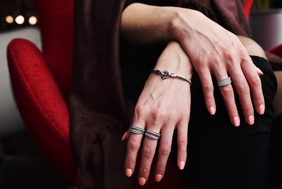 person wearing silver bracelet and rings