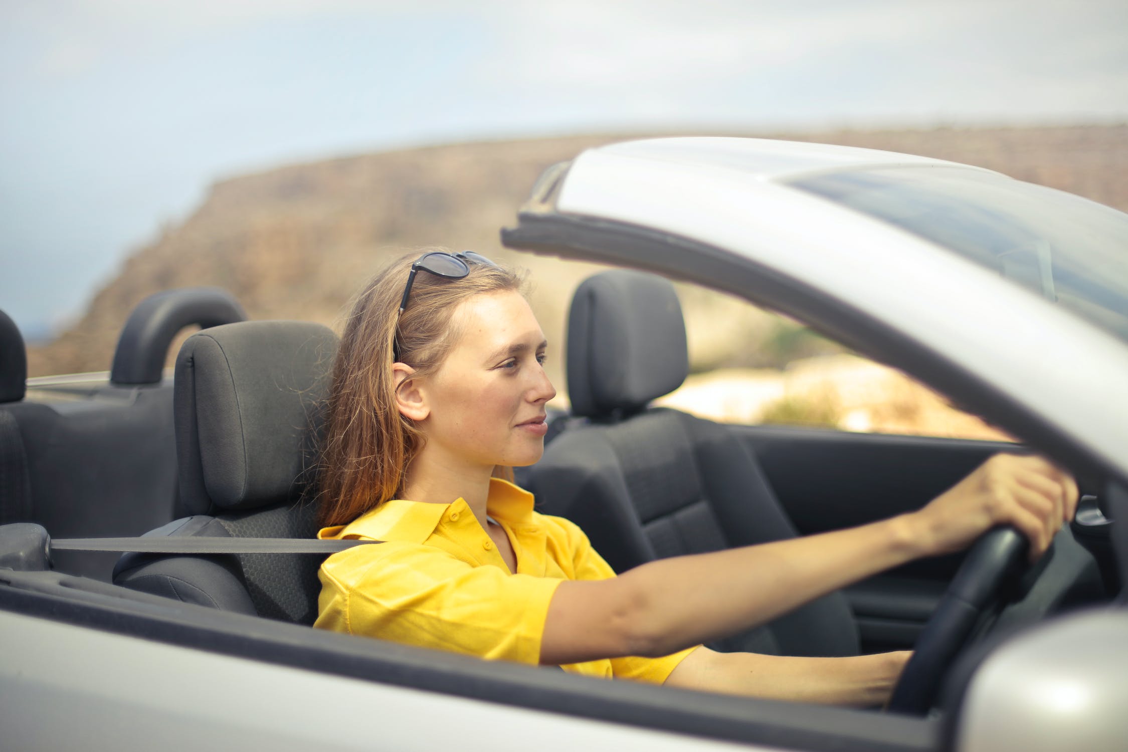 woman in yellow driving car