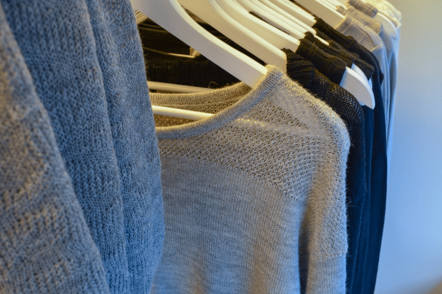 beige and black knitwears hung in a rack