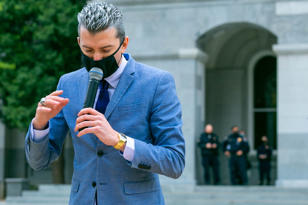 A person in a blue suit holding a mic in his hand