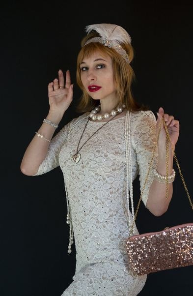 woman donning The Grea Gatsby clothing style, feather headband, handbag