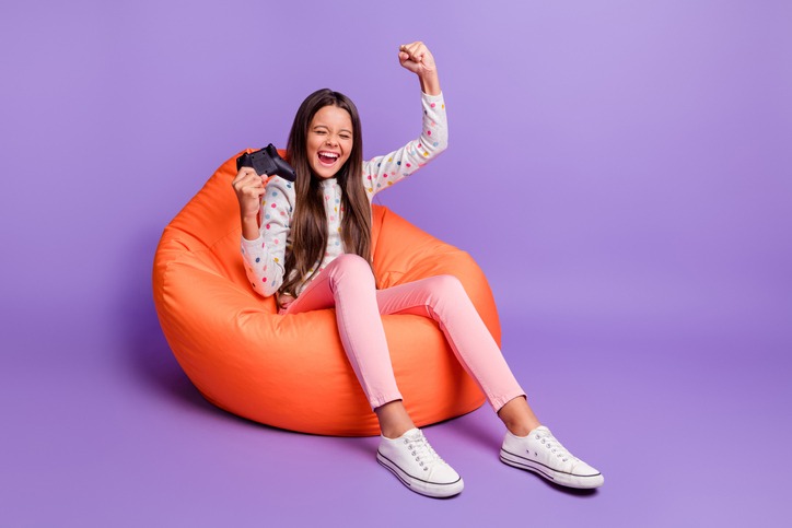 A girl playing while sitting on a beanbag chair