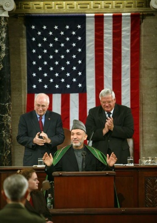 Hamid Karzai wearing a Karakul and two white men