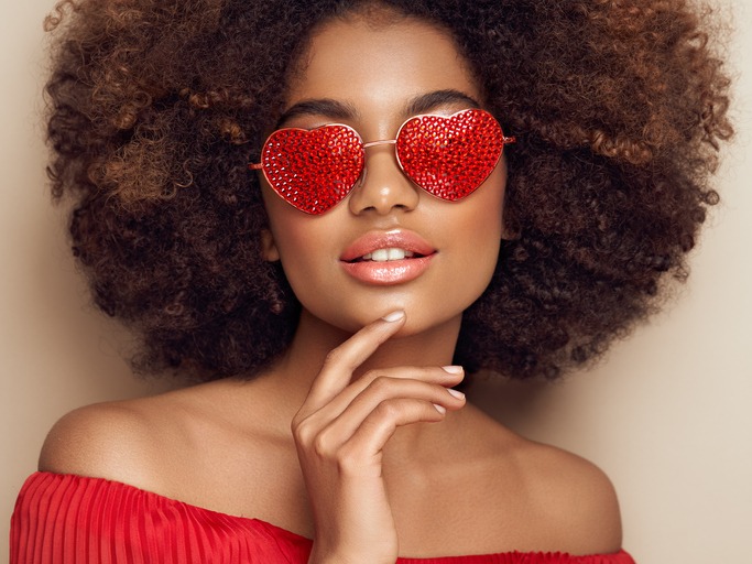 Beautiful portrait of an African girl in sunglasses in the shape of hearts