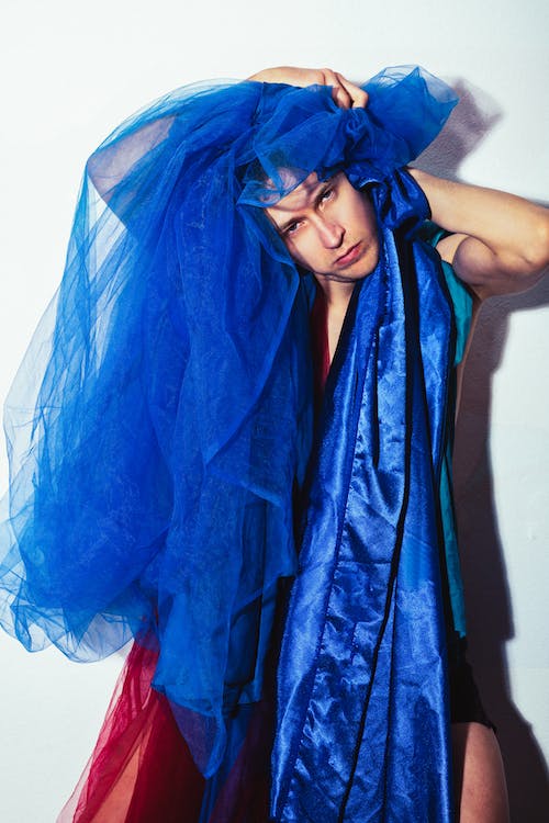 a man holding blue fabrics