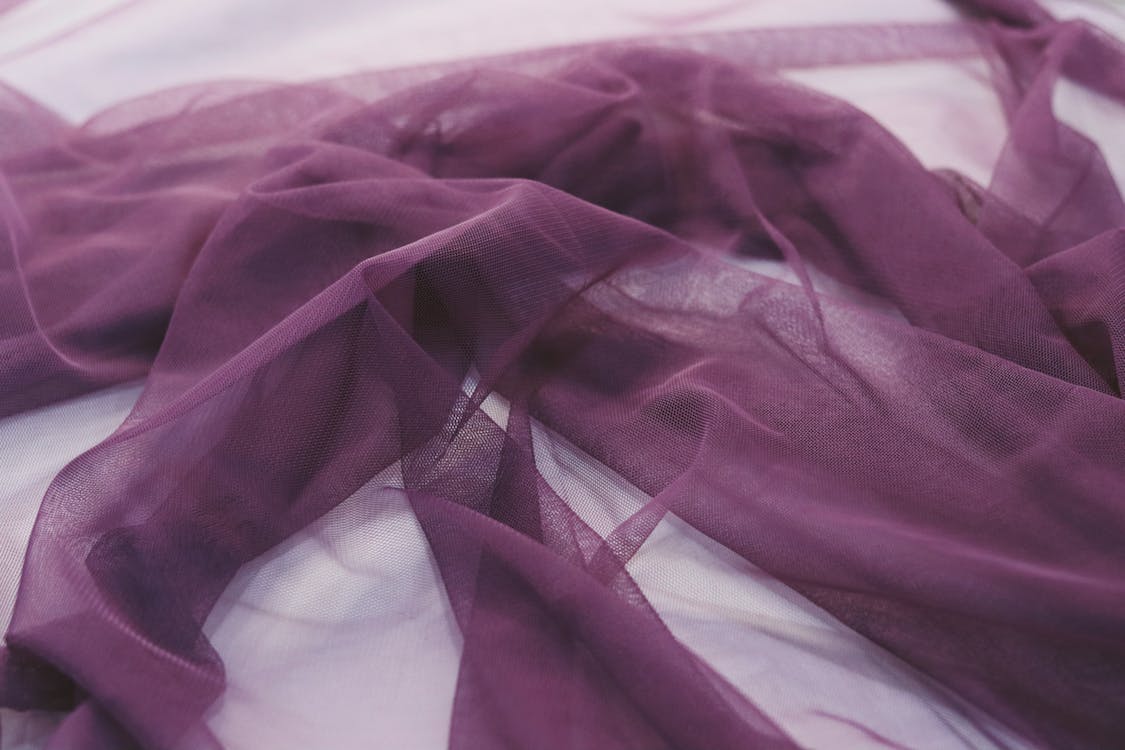 a purple chiffon fabric on a white surface