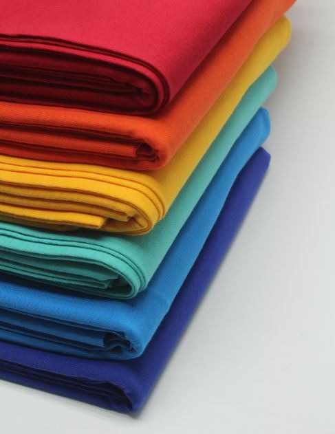 A stack of bright colored cloths on a white surface