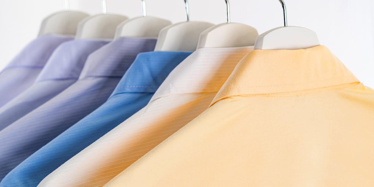 Colorful shirts for men hanging on racks in mall 