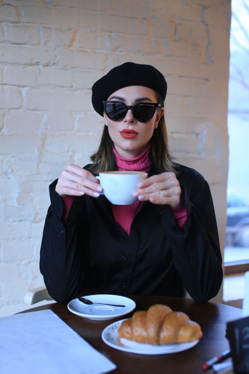 beautiful girl in a beret drinks coffee tea